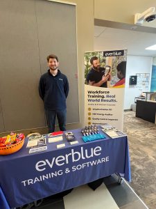 Joe Keefe standing by Everblue's exhibitor table